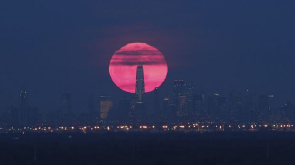 The super snow moon rises behind lower Manhattan
